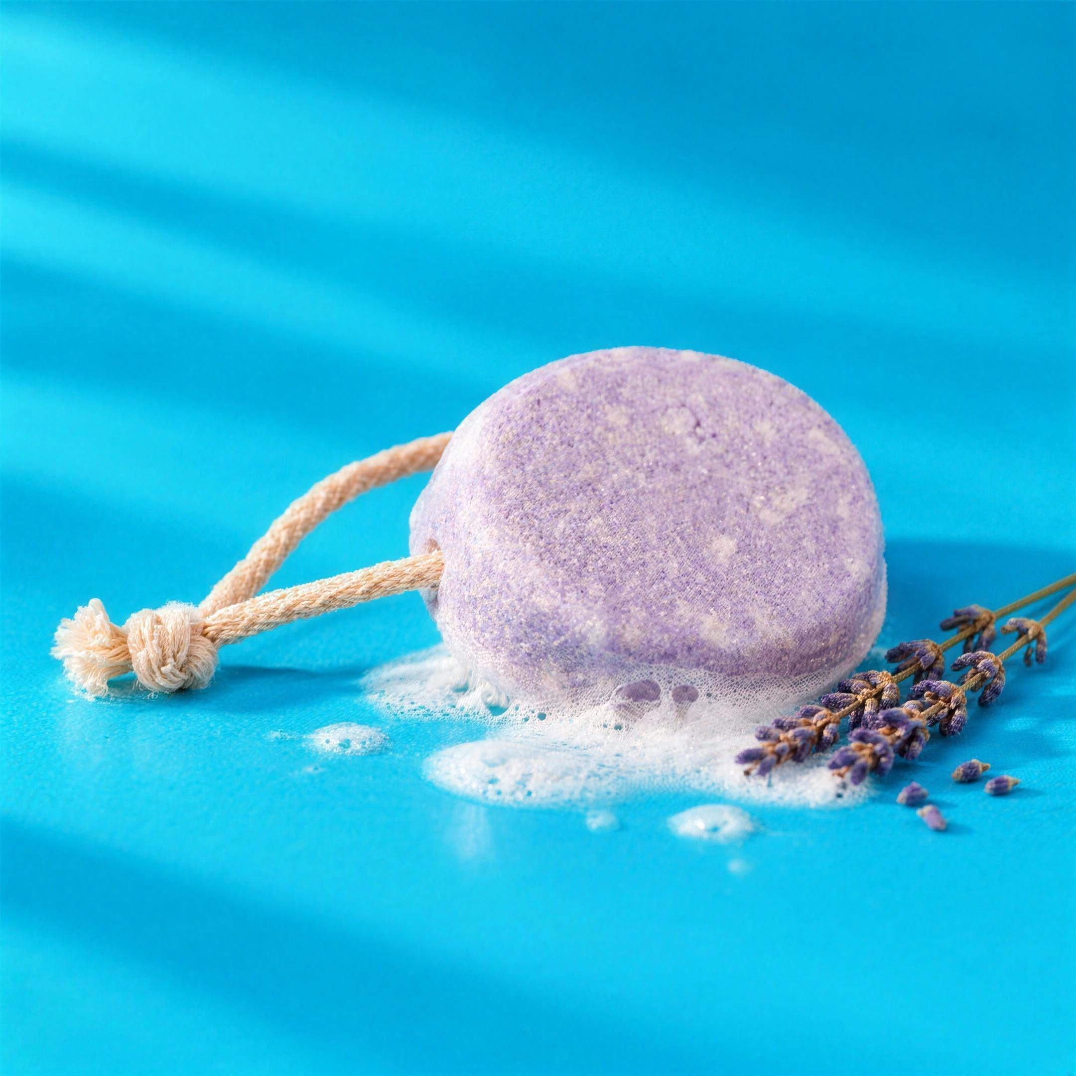 Texture del bagnodoccia solido alla lavanda: saponetta lilla con un velo di schiuma e lavanda