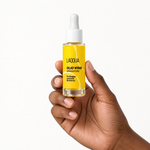 Olio viso riparatore tenuto in mano, per capire la misura (30 ml)